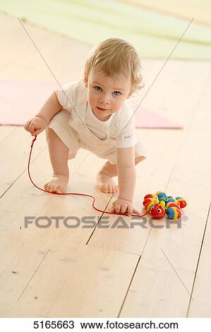 Stock Image - Toddler playing with toy . Fotosearch