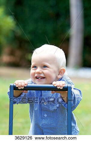 Stock Photograph - Toddler walking with walking aid . Fotosearch