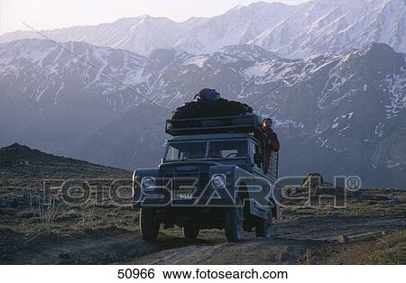 Tourist traveling in off-road vehicle with mountains in background, Alborz Mountain Range, Iran View Large Photo Image Stock Photograph - Tourist traveling in off-road vehicle with mountains in background, Alborz Mountain Range, Iran . Fotosearch