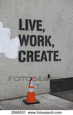 Stock Image - Traffic cone in front of a wall with stencil lettering, New York City, USA . Fotosearch