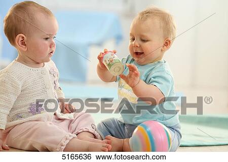 Stock Photograph - Two babies sitting on the floor . Fotosearch