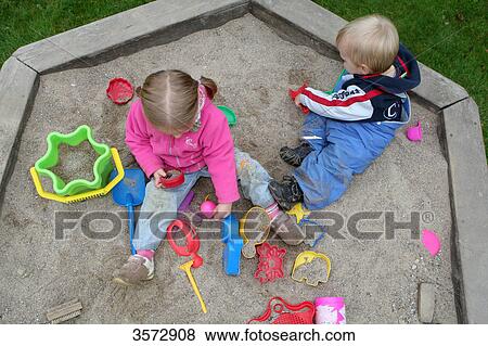 Stock Photo - Two kids playing in sandbox . Fotosearch