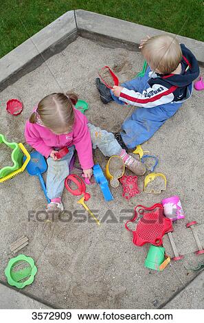 Stock Photo - Two kids playing in sandbox . Fotosearch