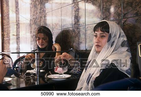 Stock Image - Two women in coffee shop, Esphahan, Iran . Fotosearch
