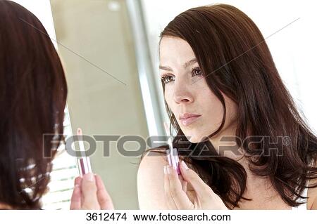 Woman applying lipgloss in bathroom View Large Photo Image Picture - Woman applying lipgloss in bathroom . Fotosearch