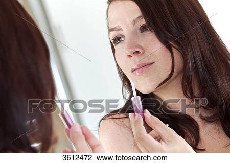 Woman applying lipgloss in bathroom View Large Photo Image Stock Image - Woman applying lipgloss in bathroom . Fotosearch