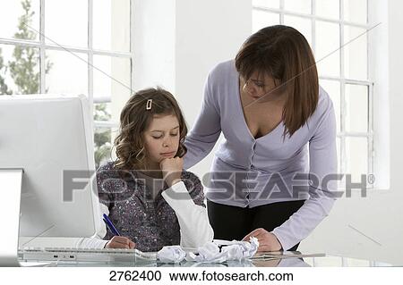 Woman helping her daughter in study View Large Photo Image Stock Image - Woman helping her daughter in study . Fotosearch