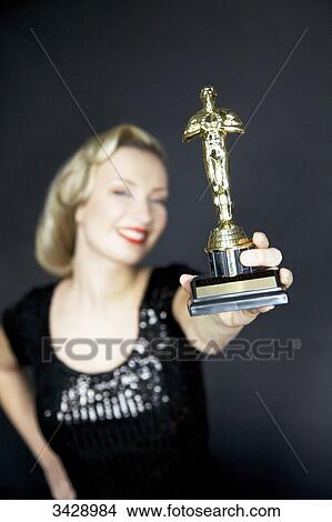 Woman holding an award at camera View Large Photo Image Picture - Woman holding an award at camera . Fotosearch