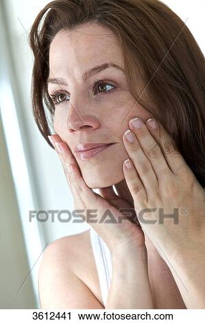 Woman in bathroom looking in mirror View Large Photo Image Stock Image - Woman in bathroom looking in mirror . Fotosearch