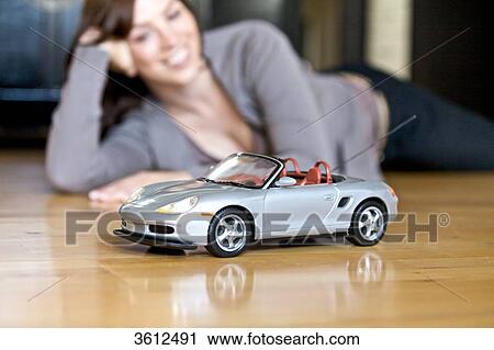 Woman lying on floor and looking at toy car View Large Photo Image Stock Image - Woman lying on floor and looking at toy car . Fotosearch