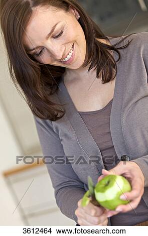 Woman peeling apple in kitchen View Large Photo Image Picture - Woman peeling apple in kitchen . Fotosearch