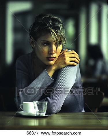 Stock Photo - Woman sitting at table . Fotosearch