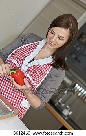 Stock Photo - Woman slicing pepper in kitchen . Fotosearch