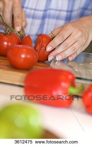 Woman slicing tomatoes in kitchen, close-up View Large Photo Image Stock Photography - Woman slicing tomatoes in kitchen, close-up . Fotosearch