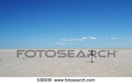 Woman standing in desert View Large Photo Image Stock Photo - Woman standing in desert . Fotosearch