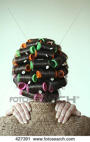 Stock Image - Woman with curler, rear view . Fotosearch