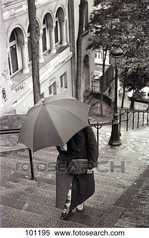 Woman with umbrella walking upstairs View Large Photo Image Stock Photography - Woman with umbrella walking upstairs . Fotosearch