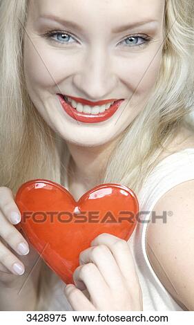Young woman holding a heart, portrait View Large Photo Image Stock Photography - Young woman holding a heart, portrait . Fotosearch