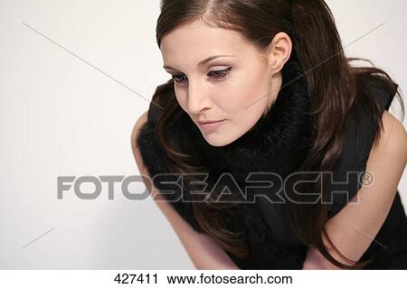 Stock Image - Young woman looking down . Fotosearch