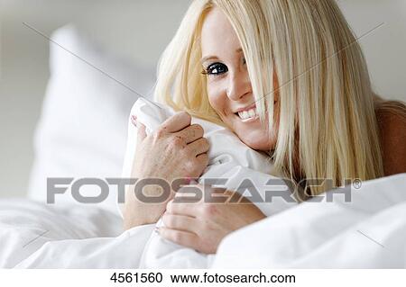 Young woman lying in bed View Large Photo Image Stock Image - Young woman lying in bed . Fotosearch