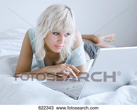 Stock Image - Young woman using laptop . Fotosearch