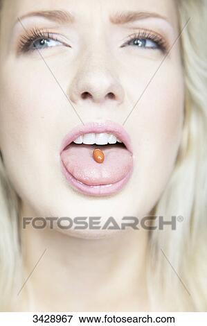 Young woman with a pill on her tongue, close-up View Large Photo Image Stock Photo - Young woman with a pill on her tongue, close-up . Fotosearch