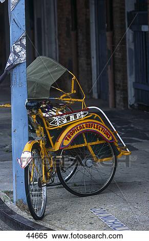 Stock Photography - Bicycle rickshaw chained with pole at roadside, French Quarter, New Orleans, Louisiana, USA . Fotosearch
