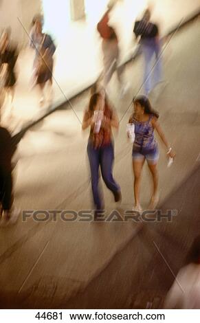 Blurred view of two young women walking on street, Bourbon Street, New Orleans, Louisiana, USA View Large Photo Image Stock Image - Blurred view of two young women walking on street, Bourbon Street, New Orleans, Louisiana, USA . Fotosearch