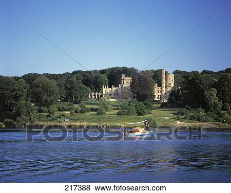 Stock Photo - Boat in river in front of castle, Potsdam-Babelsberg, Germany . Fotosearch