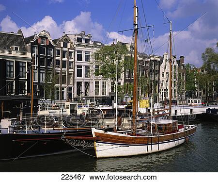 Stock Photo - Boats moored at harbor, Amstel River, Amsterdam, Netherlands . Fotosearch