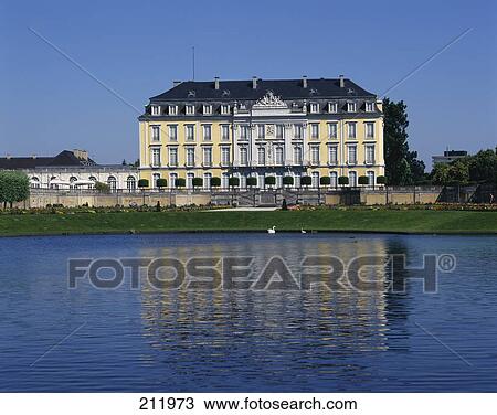 Stock Image - Castle at waterfront against blue sky, Bruehl Castle, Cologne, Germany . Fotosearch