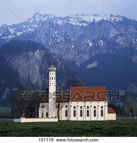 Stock Photo - Church on landscape with mountain range in background, Sank Coloman Church, Swabian, Bavaria, Germany . Fotosearch