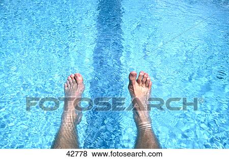 Stock Photo - Close-up of person's feet in swimming pool . Fotosearch