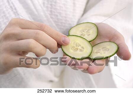 Close-up of person's hand holding three slices of cucumber View Large Photo Image Stock Image - Close-up of person's hand holding three slices of cucumber . Fotosearch