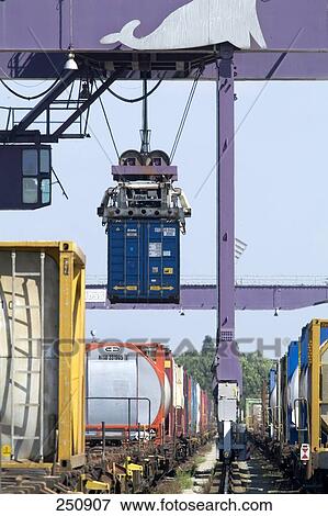 Stock Photo - Crane hoisting container at railway station, Duisburg, Ruhr Basin, North Rhine-Westphalia, Germany . Fotosearch