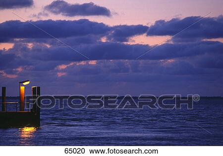 Electric light lit up at dusk on pier View Large Photo Image Stock Image - Electric light lit up at dusk on pier . Fotosearch