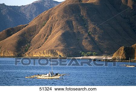 Picture - Fishing boat in sea at sunset, Komodo Island, Indonesia . Fotosearch