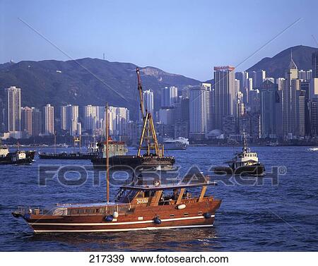Fishing boats in river with city in background View Large Photo Image Stock Photo - Fishing boats in river with city in background . Fotosearch