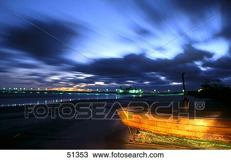 Stock Image - House lit up at dawn on beach, Ahlbeck Pier, Usedom Island, Germany . Fotosearch