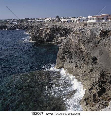 Stock Photo - Houses on cliff at coast, Minorca, Balearic Islands, Spain . Fotosearch
