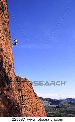 Stock Photo - Low angle view of a hiker scaling a cliff, Grand Canyon National Park, Nevada, USA . Fotosearch