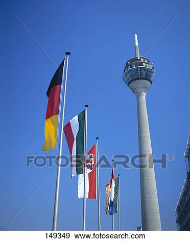 Stock Photo - Low angle view of communication tower and flags, Düsseldorf, North Rhine Westphalia, Germany . Fotosearch