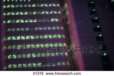 Stock Photograph - Low angle view of office building lit up at night . Fotosearch
