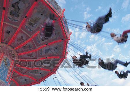 Stock Photo - Low angle view of people on chairoplane, Oktoberfest, Munich, Bavaria, Germany . Fotosearch