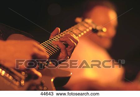 Low angle view of person playing guitar View Large Photo Image Stock Image - Low angle view of person playing guitar . Fotosearch