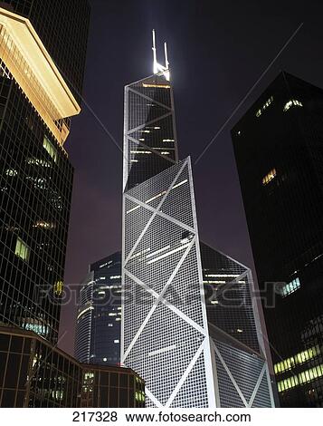 Stock Photo - Low angle view of skyscrapers lit up at night . Fotosearch