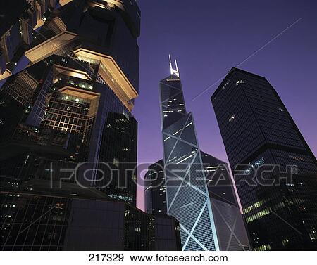 Stock Photo - Low angle view of skyscrapers lit up at night . Fotosearch