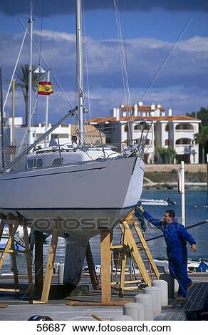 Man repairing boat at dock, Colonia de Sant Jordi, Majorca, Balearic Islands, Spain View Large Photo Image Stock Photo - Man repairing boat at dock, Colonia de Sant Jordi, Majorca, Balearic Islands, Spain . Fotosearch