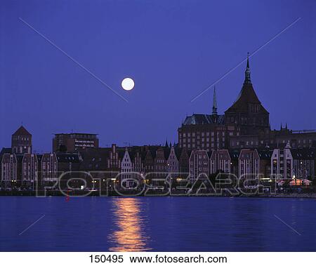 Moon over city at waterfront, Rostock, Germany View Large Photo Image Stock Photography - Moon over city at waterfront, Rostock, Germany . Fotosearch