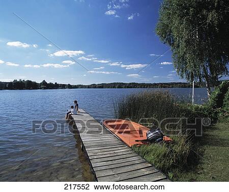 Stock Image - Motorboat besides a pier in river waters . Fotosearch